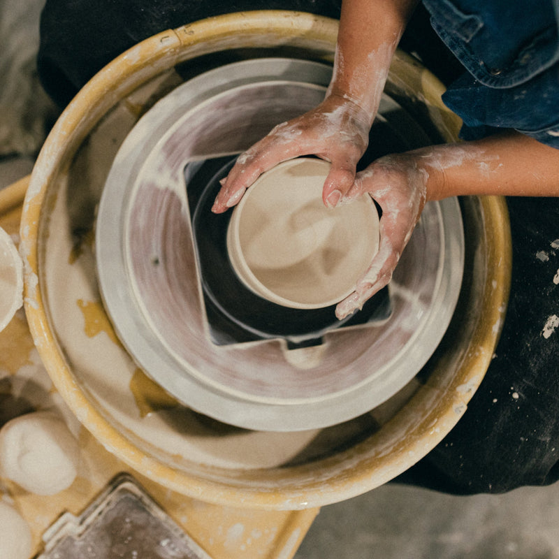Person working with clay on a pottery wheel